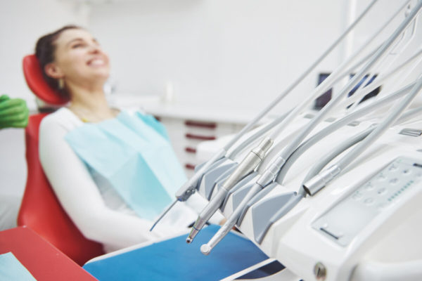 Young female patient sitting on chair in dental office.preparing for dental exam